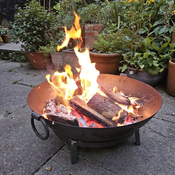 60cm Kadai steel fire pit bowl with a stainless steel cooking grill on a UK garden patio